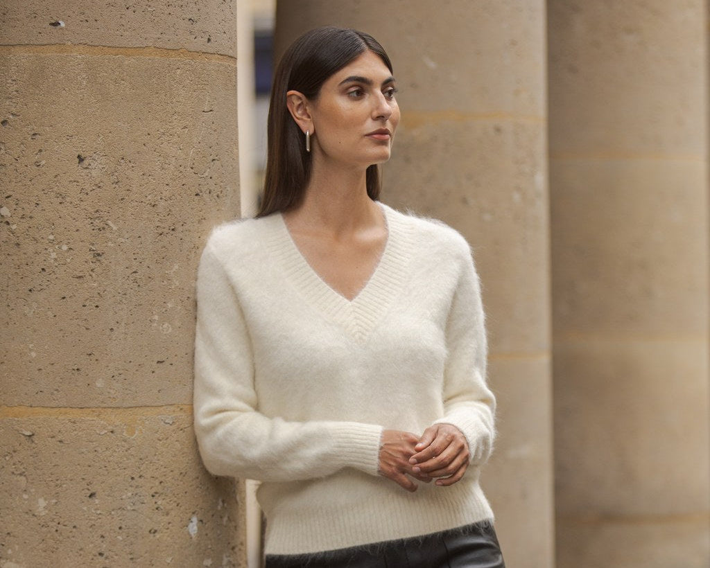 Valkoinen lyhythihainen alpakkaneule sekä hartioilla pitkähihainen vaalea neule