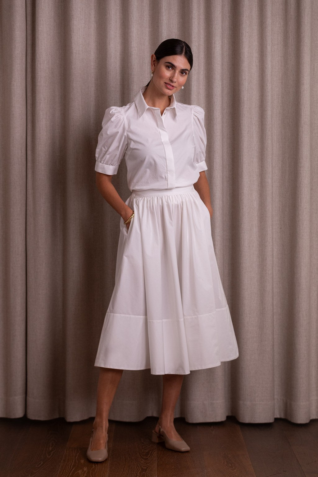 Puuvillasta valmistettu valkoinen hame, jossa leveä käänne.