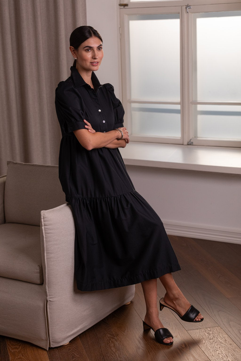 Nainen, jonka päällä Original Storyn musta puhvihihallinen puuvillasekoitemekko.