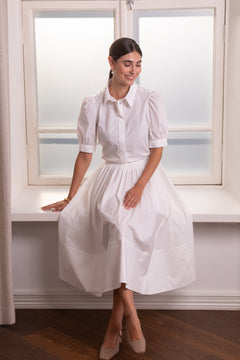 Nainen, jonka päällä on Original Storyn puuvillasta valmistettu valkoinen leveähelmainen hame.