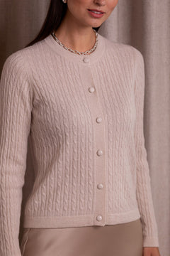 Lähikuva kashmirista valmistetusta ohuesta palmikkoneuletakista, sävyssä latte