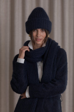 Paksu kaulahuivi tummansinisen neuletakin kanssa