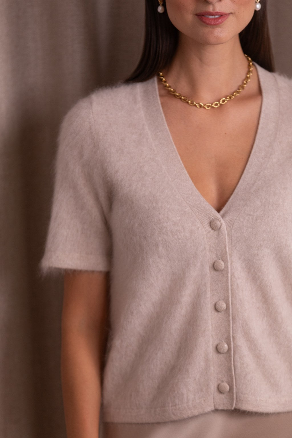 Kashmirista valmistettu lyhythihainen neuletakki, jossa v-kaula-aukko, sävyssä latte